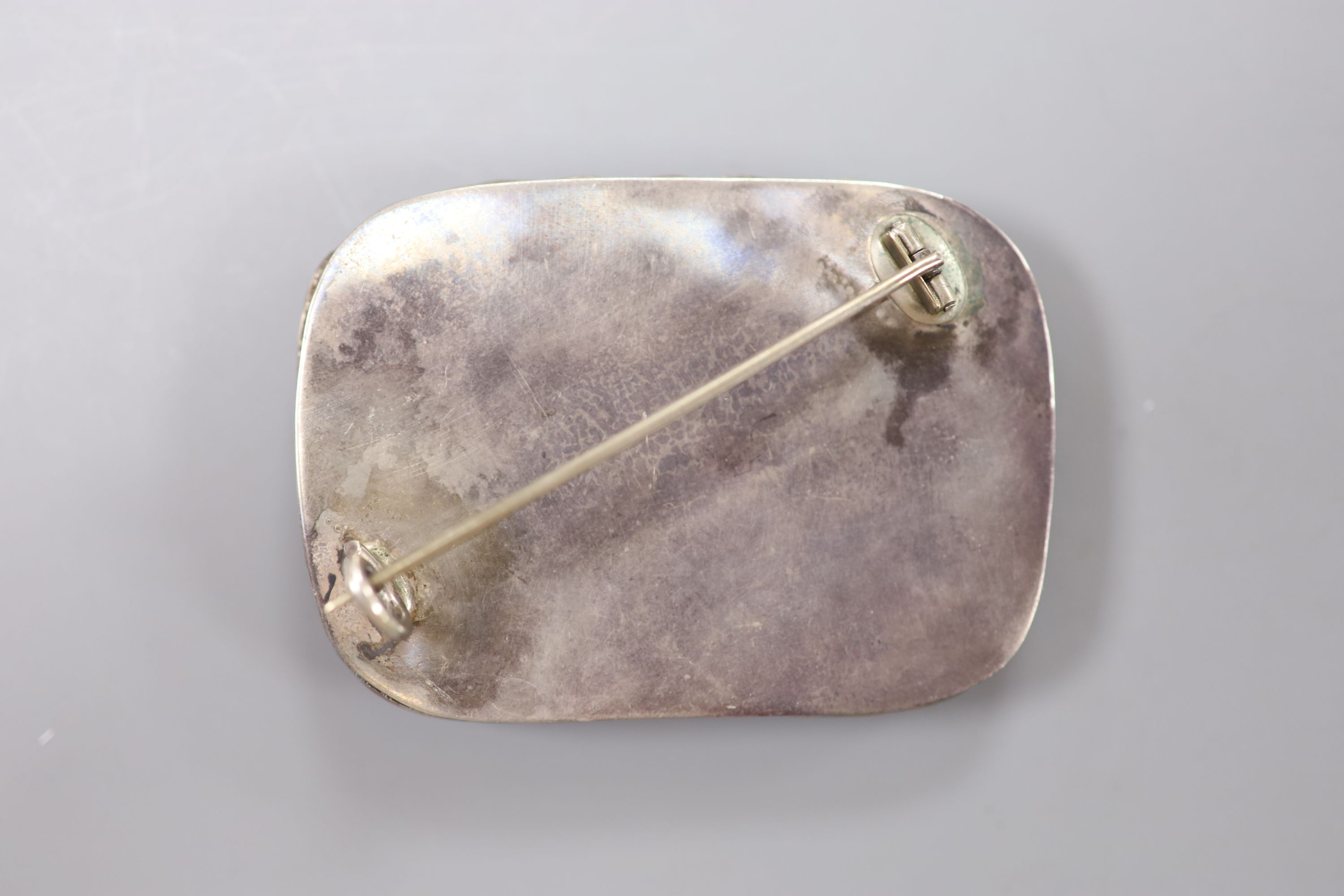 A mid 20th century Chinese? white metal and polychrome enamel brooch, decorated with hare, and ladybird amongst foliage, 58mm, gross 34 grams, (enamel a.f.).